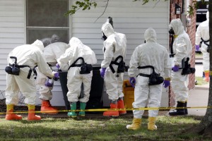 FILE - In this Friday, April 19, 2013 file photo, federal agents wearing hazardous material suits inspect a trash can outside the house of Paul Kevin Curtis