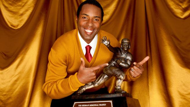 Charlie Ward posing with the Heisman Trophy. 