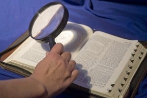 Bible with magnifying glass