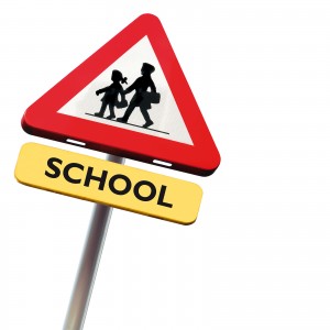 Back to school: roadsign with warning for crossing schoolkids is