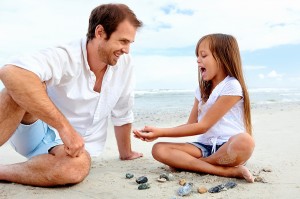 Father and daughter day at the beach collecting shells together
