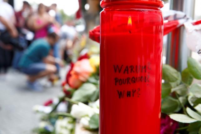 A candle with the words 'Why?' written upon it is placed next to flowers near the Olympia shopping mall, where yesterday's shooting rampage started, in Munich, Germany July 23, 2016. REUTERS/Arnd Wiegmann