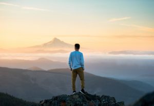 man-standing-on-top-of-mountain