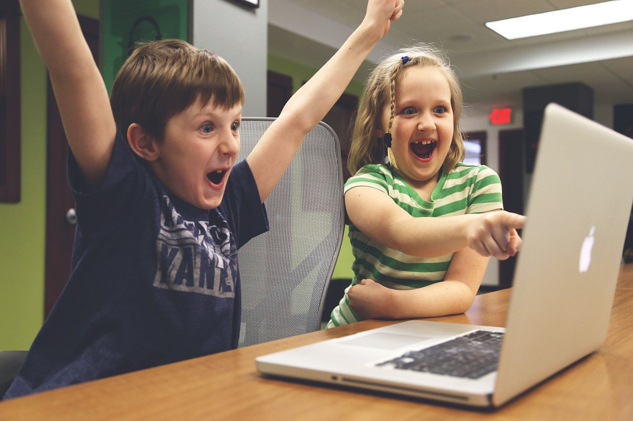 Children excited at computer screen.