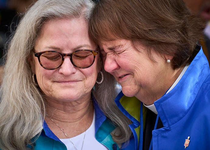 A lesbian couple crying together over United Methodist Church allowing LGBTQ clergy