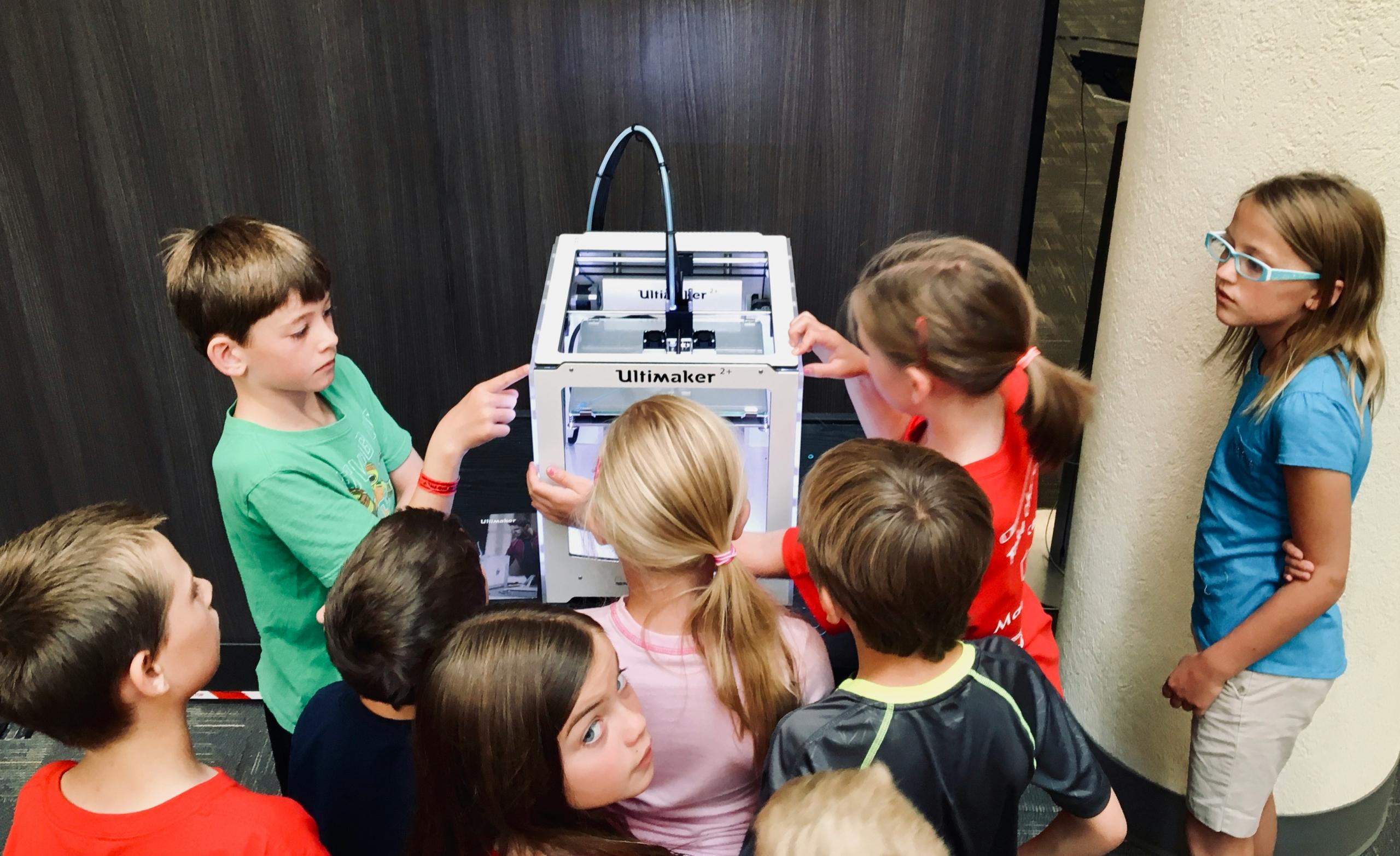 3rd grade students standing around a 3D printer in the classroom