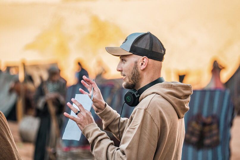 A man with headphones instructing people dressed as Biblical characters