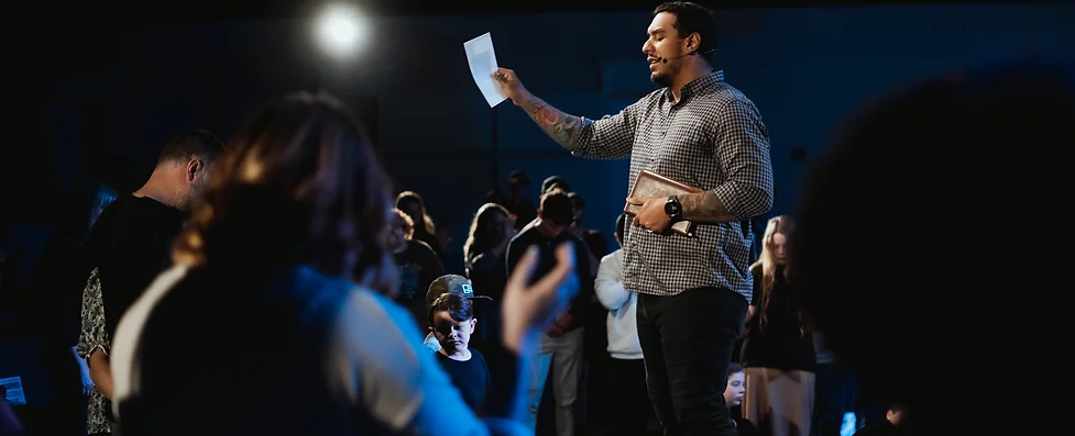 Man holding up a medical bill praying over it in church