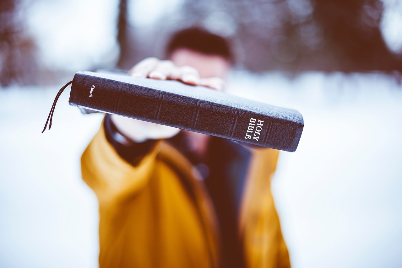 A young person holding a bible.