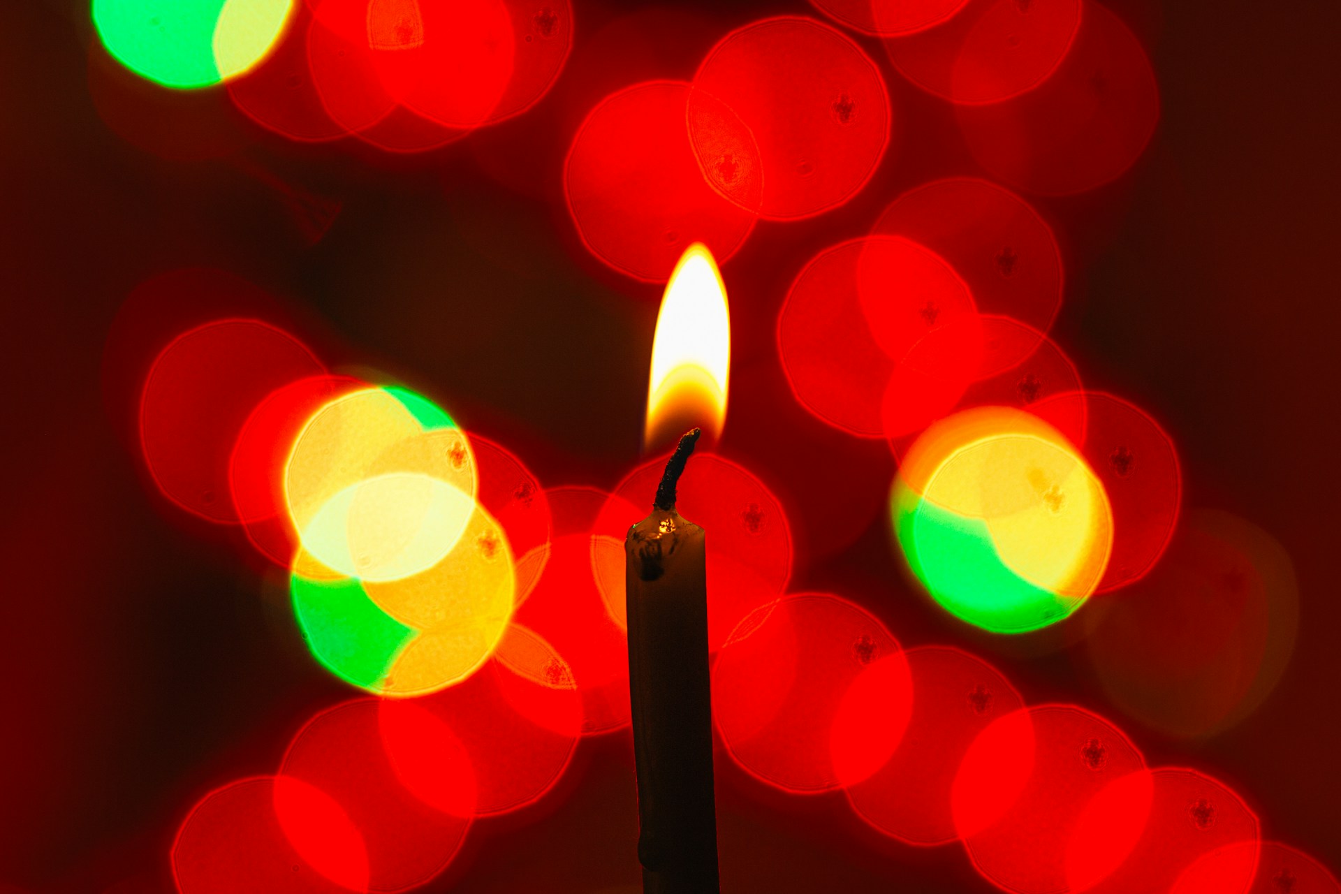 A single candle lit surrounded by red light