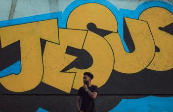 Jesus graffiti with young black man in front of wall