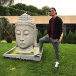 Cristiano Ronaldo poses with Buddha statue.